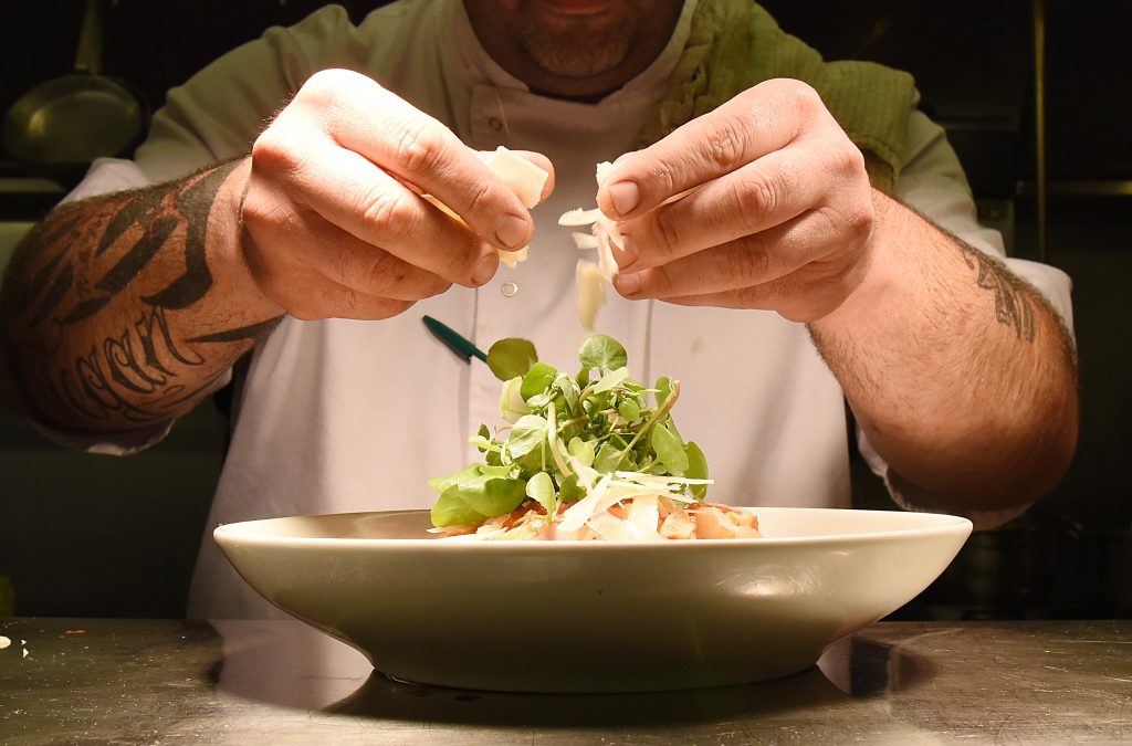 Chef adding final touches to a dish.